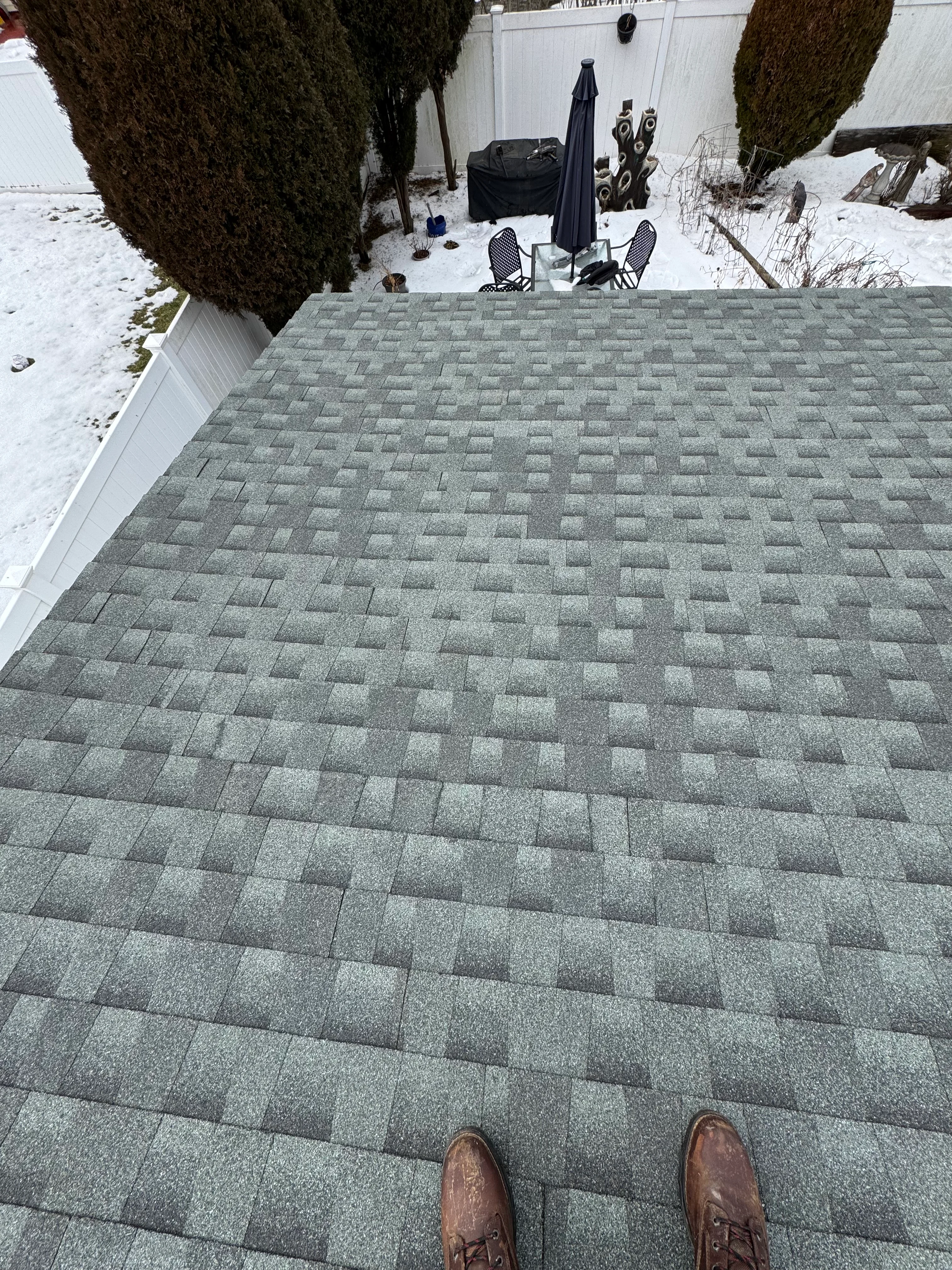 New gray architectural shingle roof installation on residential home in winter