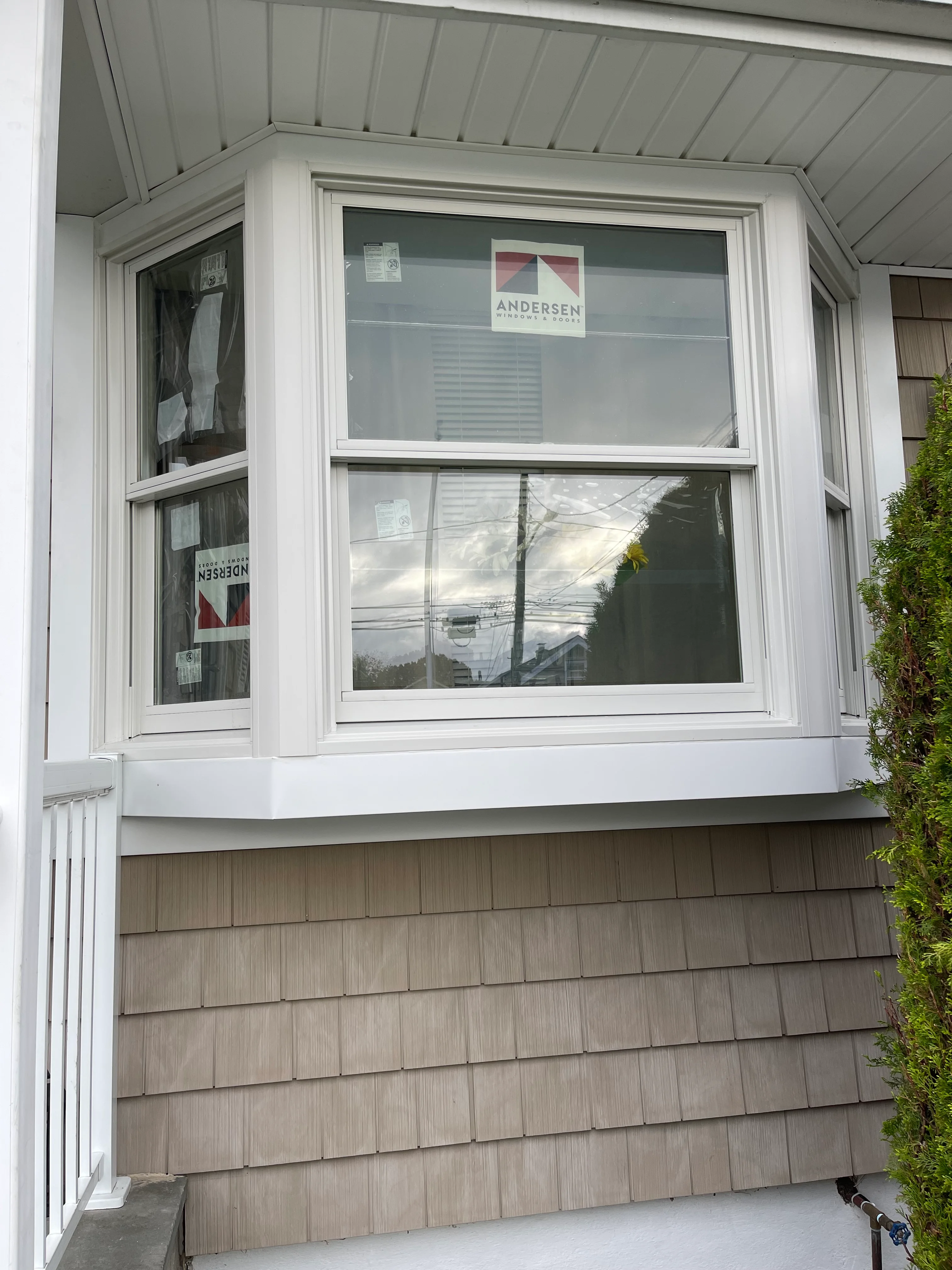 White Andersen double-hung windows with vinyl trim installed on residential home exterior