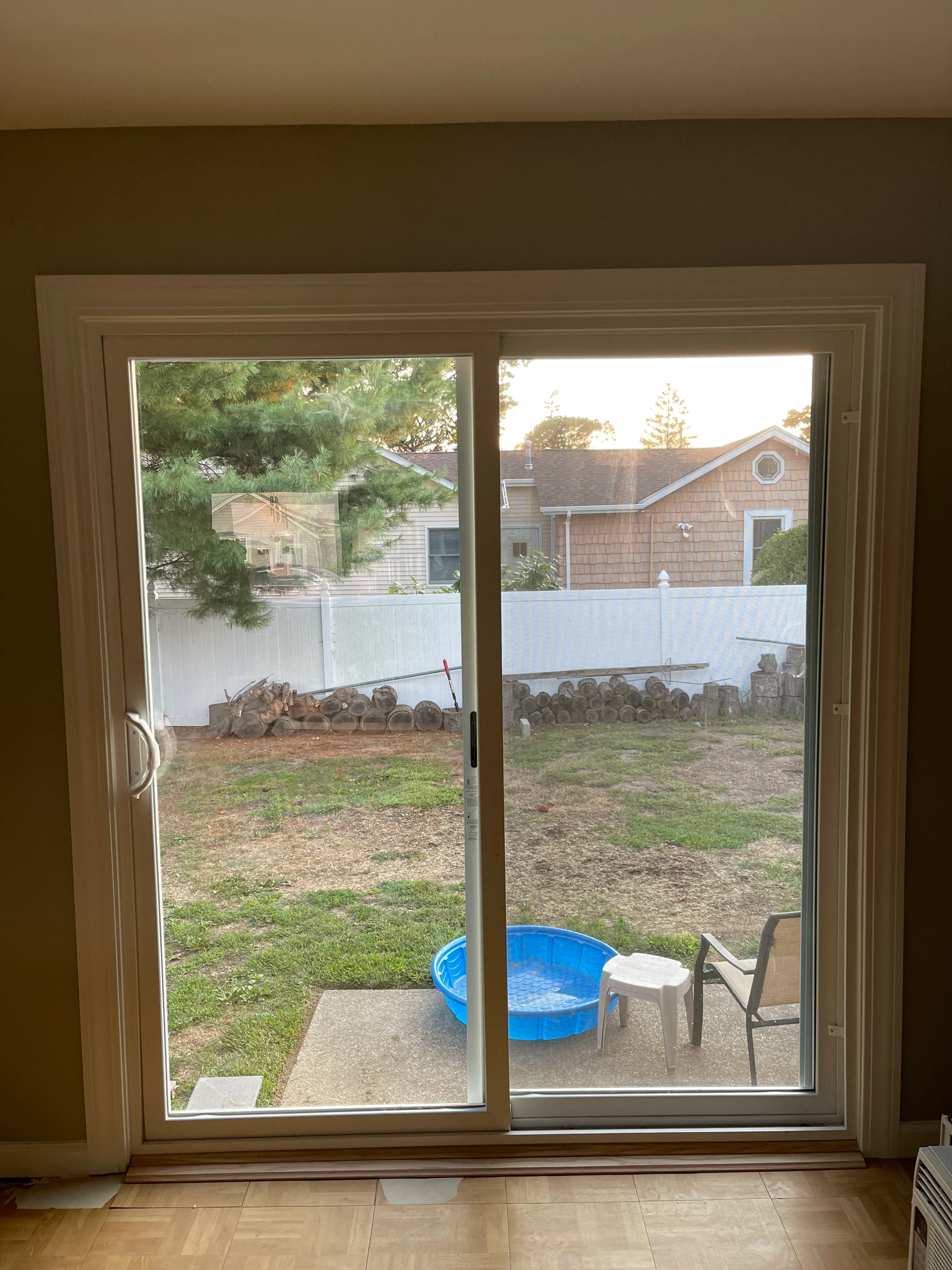 New tan sliding glass doors opening to backyard patio with pool and seating