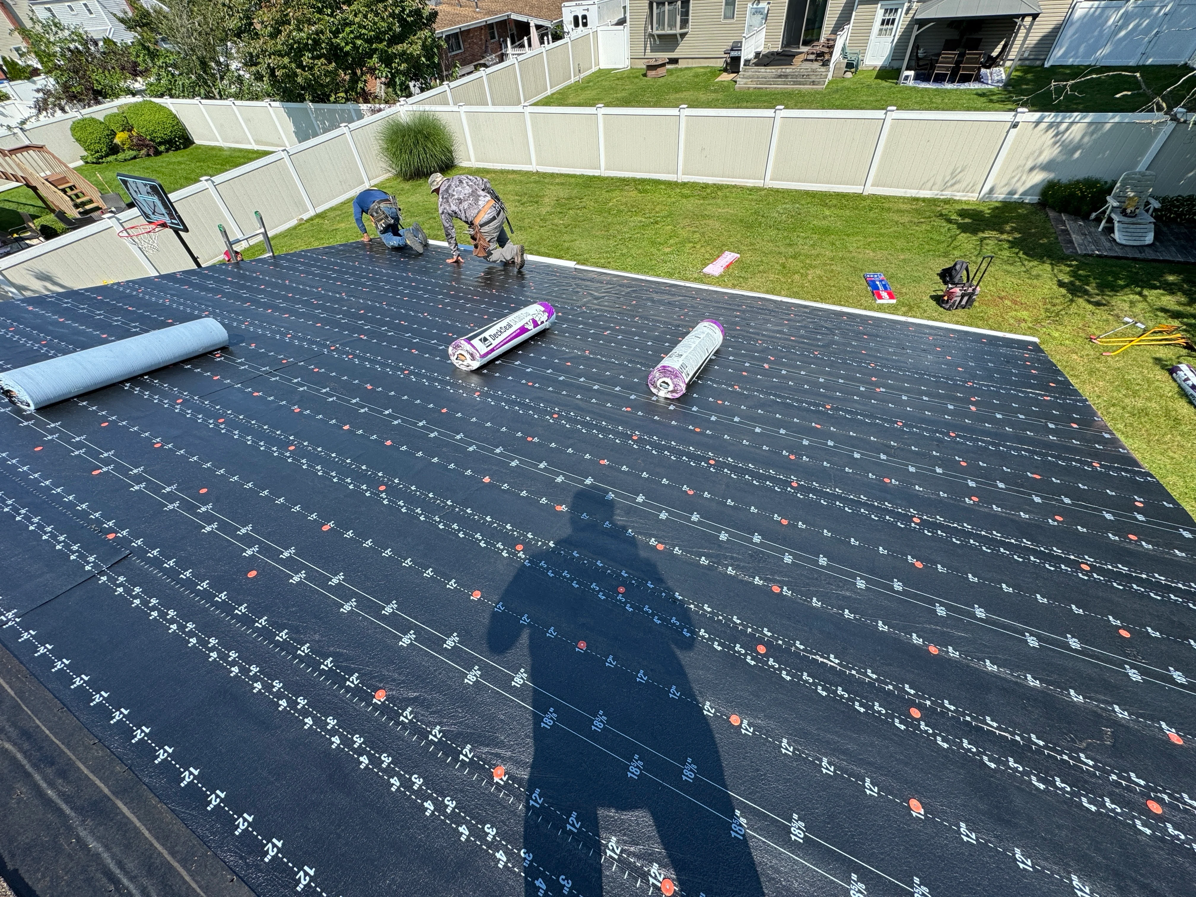 Architectural shingles being installed on residential roof with fastening pattern visible