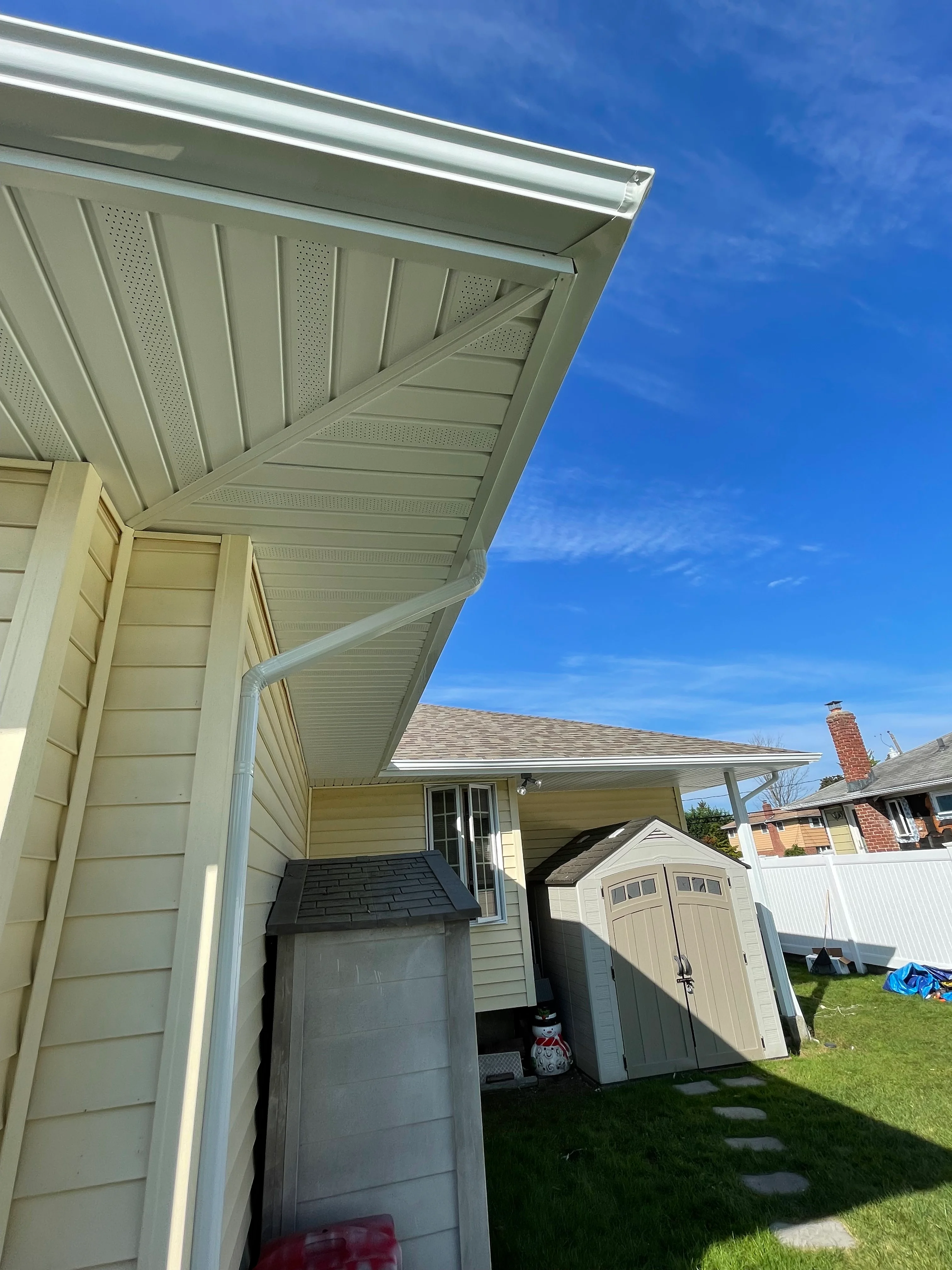 New cream-colored vinyl soffit and aluminum fascia installed on residential home exterior