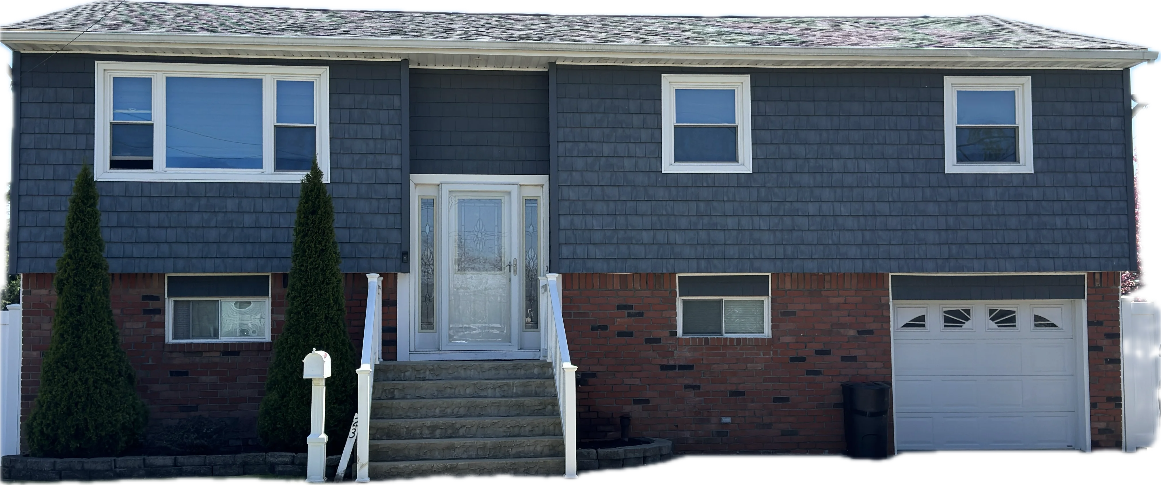Two-story split-level home with new blue siding, roof, windows, and garage door in Lindenhurst