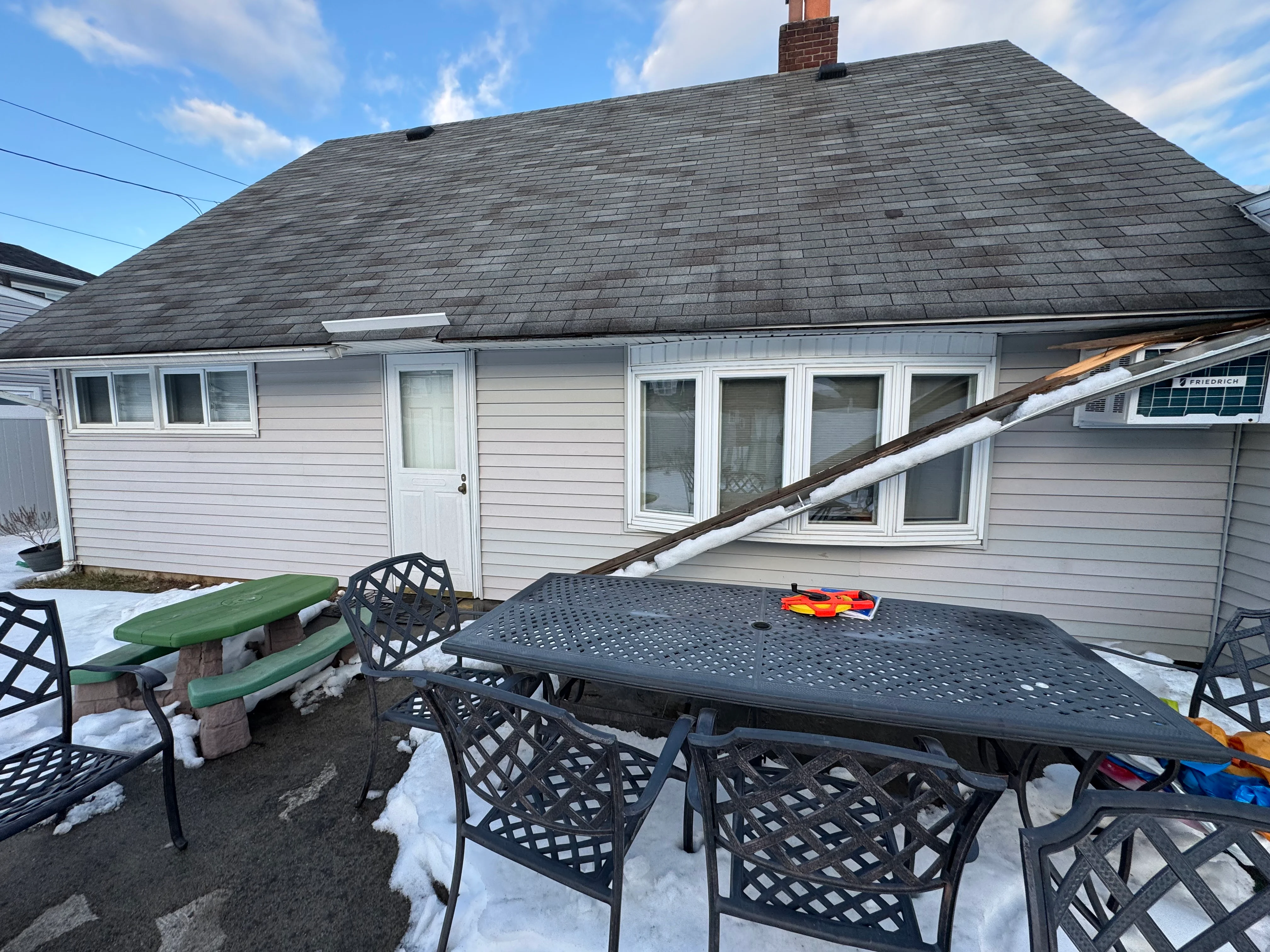 White vinyl-sided home with new charcoal roof and replacement windows in Lindenhurst