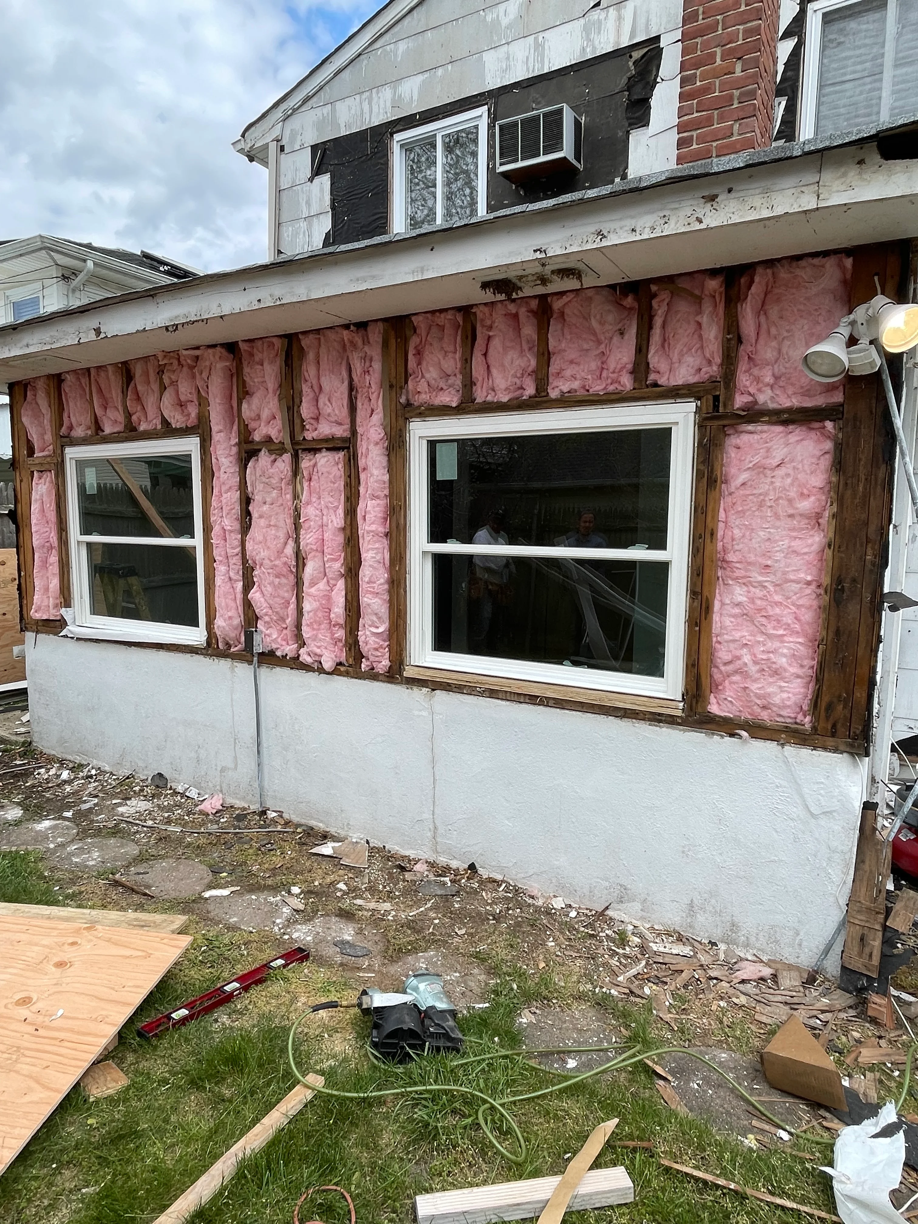 Home addition under construction with pink insulation and new windows installed