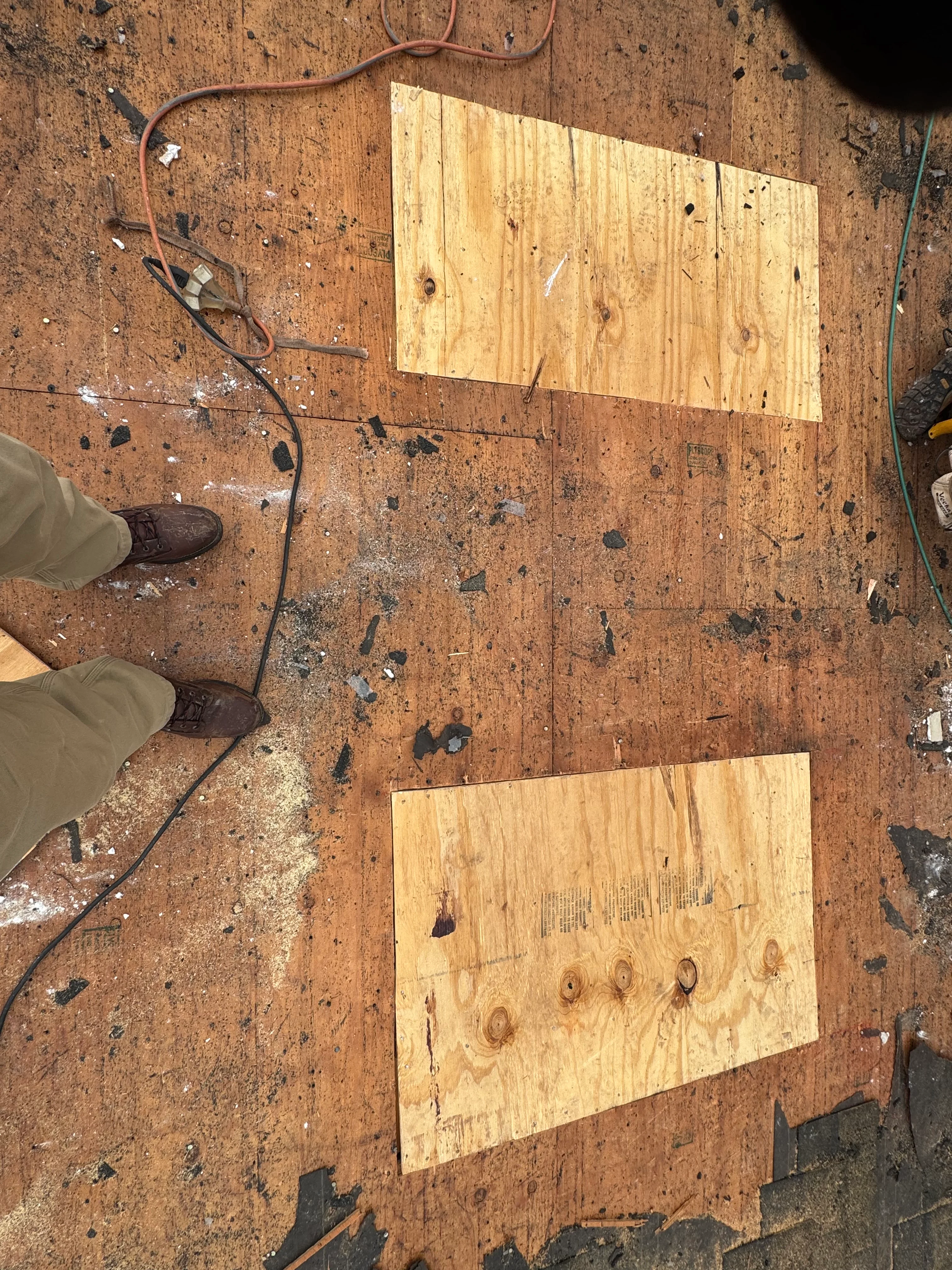 Hardwood floor repair with new pine boards fitted into damaged sections of original flooring