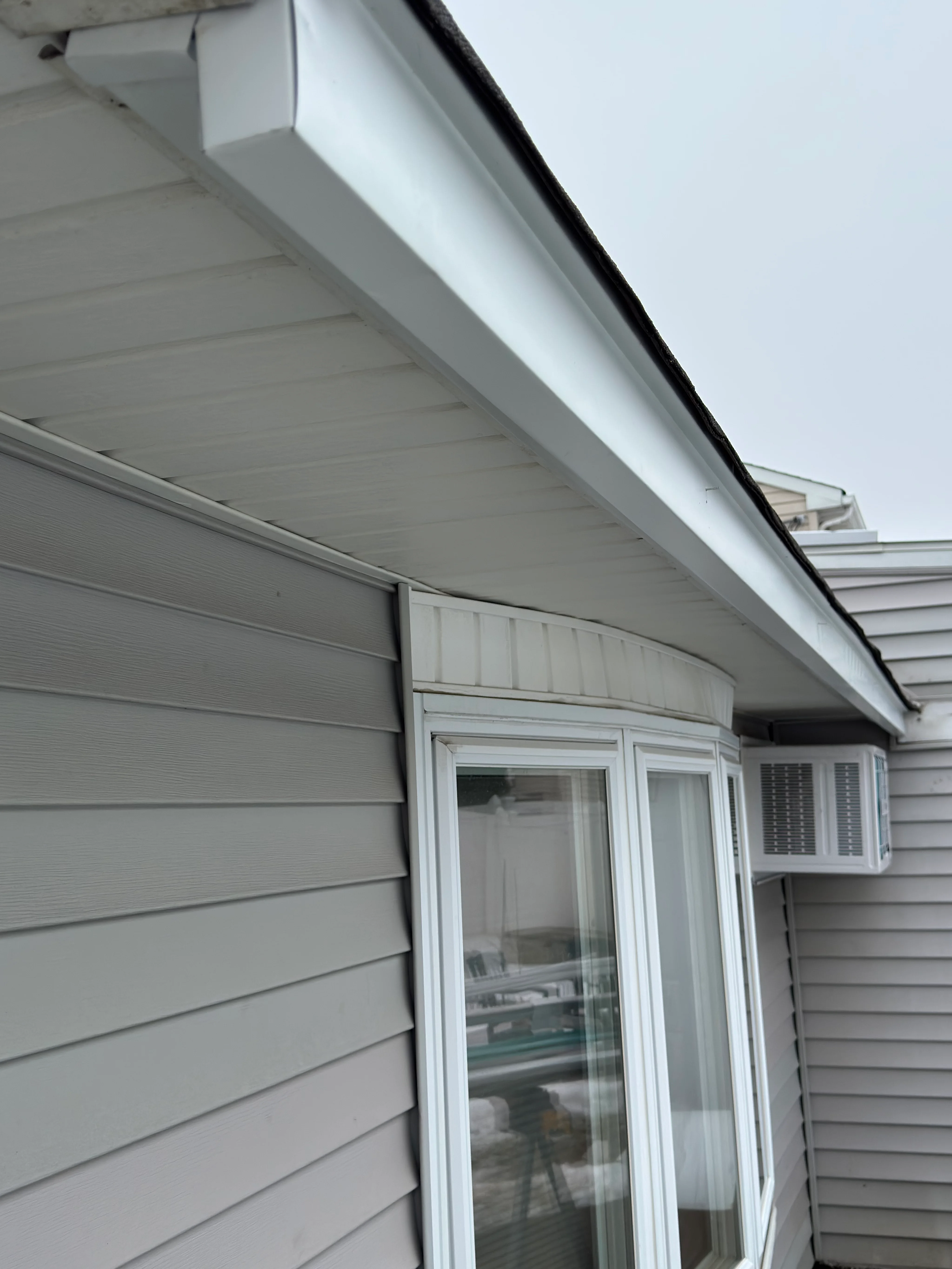 White aluminum soffit and fascia installation with integrated lighting along roofline