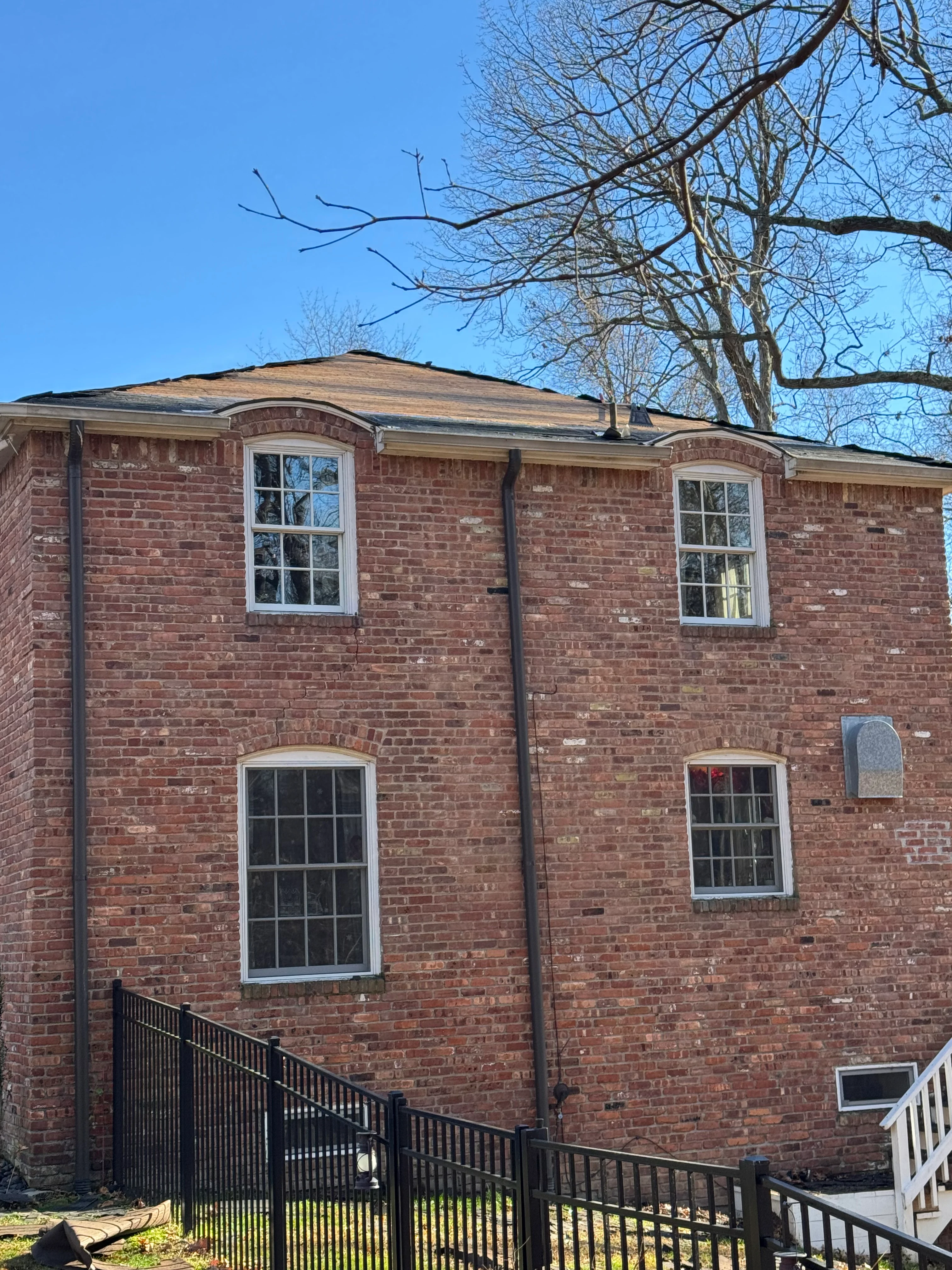 Two-story brick home with new roof and white-trimmed windows